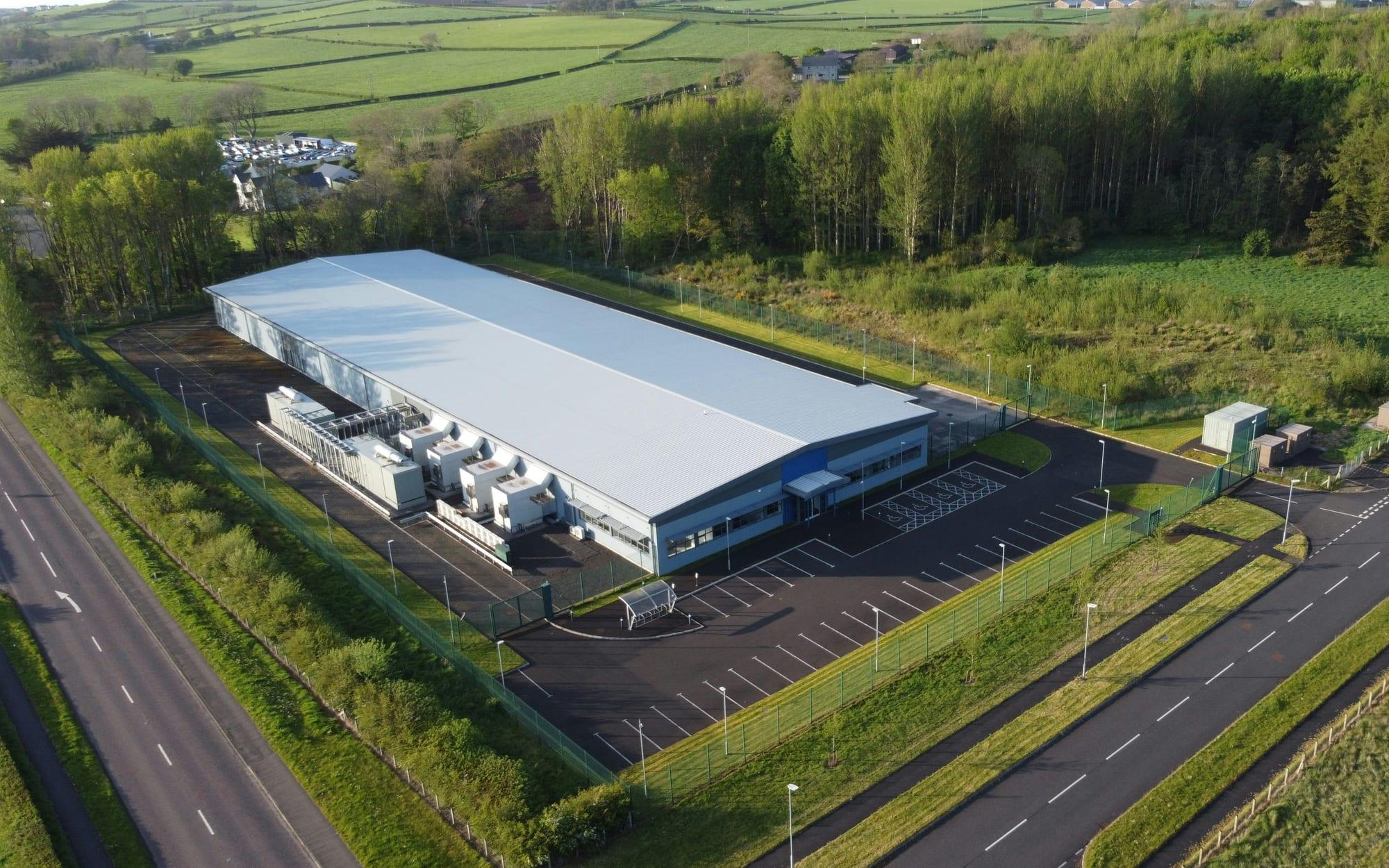 Aerial view of a data centre building surrounded by fields