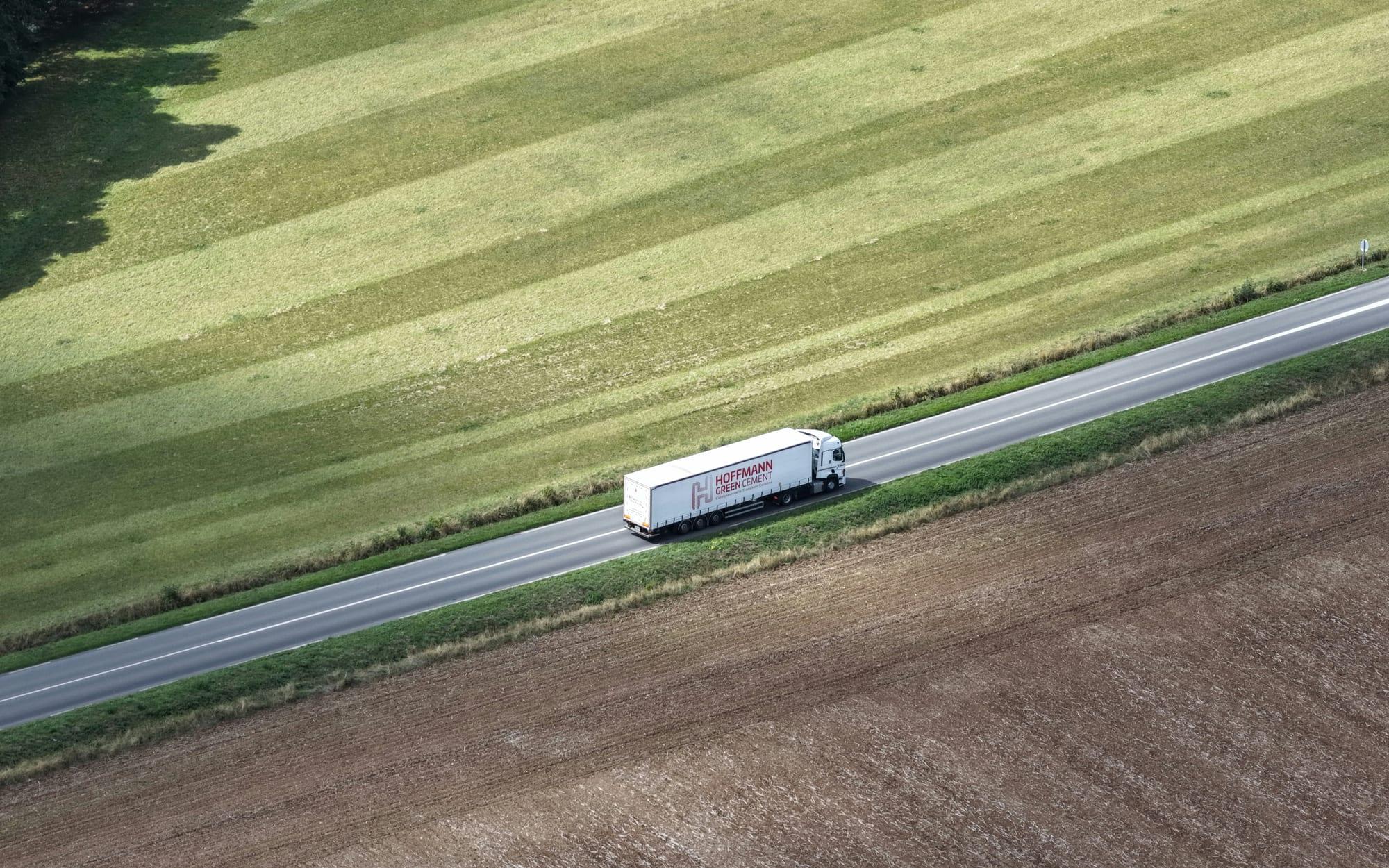 Truck on a rural road between paddocks, seen from above